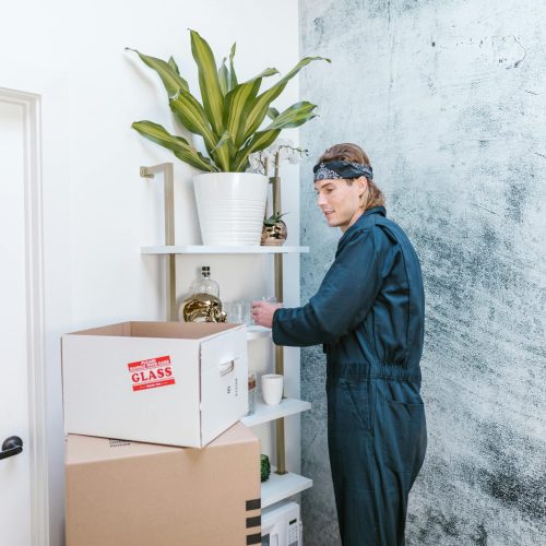 Cleaner organizing moving boxes while deep cleaning an empty home